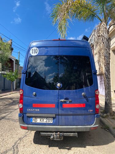 Das Heck eines blauen Wohnmobils. Es ist beklebt mit zwei roten Reflektionsstreifen und einem weißen max. Geschwindigkeits-Aufkleber.