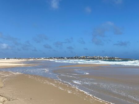 Blauer Himmel, Strand und Meer. In der Ferne das Hippie-Dorf Cabo Polonio.