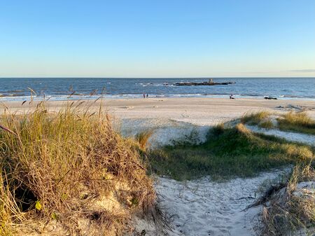Dünenlandschaft im Abendlicht im Vordergrund und der Atlantik im Hintergrund. Panoramablick auf den Strand von Atlántida in Uruguay.
